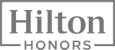 The image is a black and white "Hilton Honors" logo with the text enclosed in a rectangular border.
