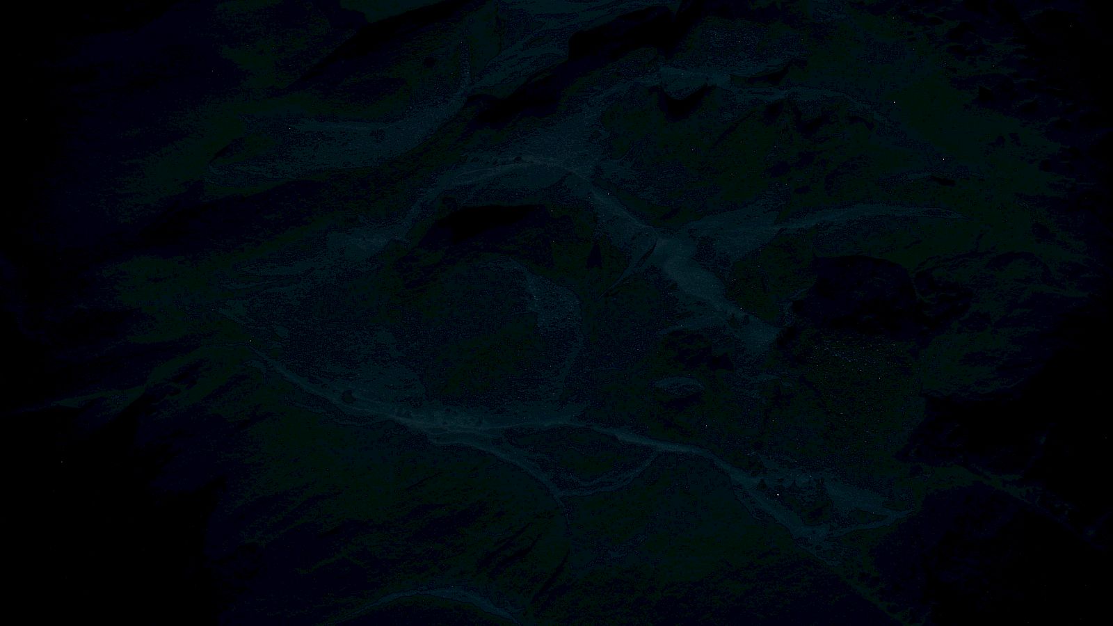 The image appears extremely dark with indistinct patterns or textures, making it difficult to discern specific details or subjects.